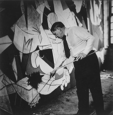 Picasso debout travaillant à Guernica dans son atelier des Grands-Augustins